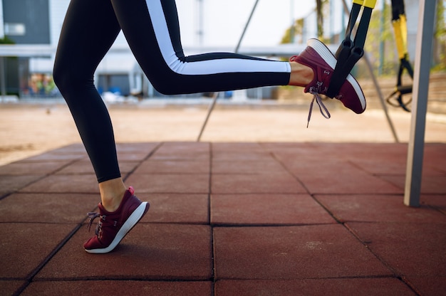 Foto frau, die streckübung mit seilen auf sportplatz im freien tut