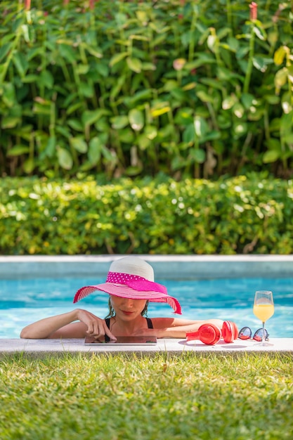 Frau, die Tablet-Computer im Pool verwendet