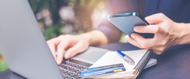 Frau, die Telefon und Laptop verwendet, um im Internet zu suchen