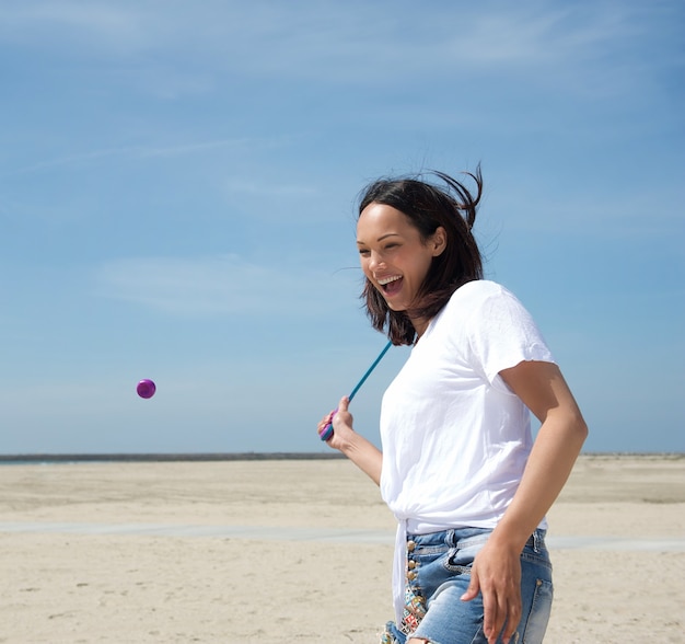 Frau, die Tennis am Strand spielt