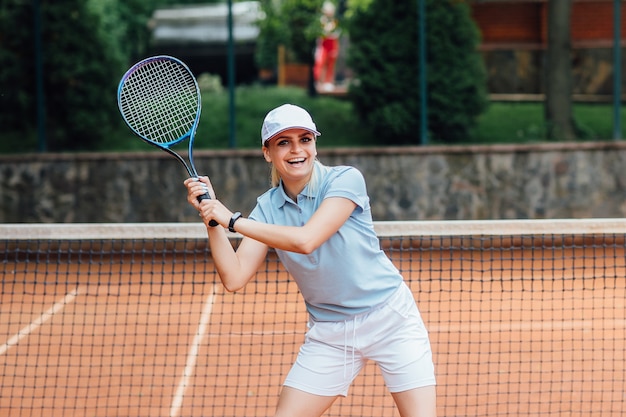 Frau, die Tennis spielt und auf den Service wartet.