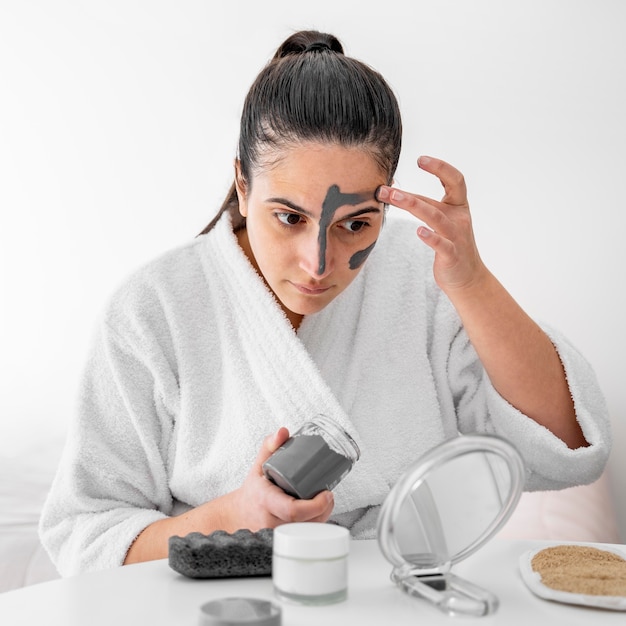 Foto frau, die tongesichtsmaske anwendet