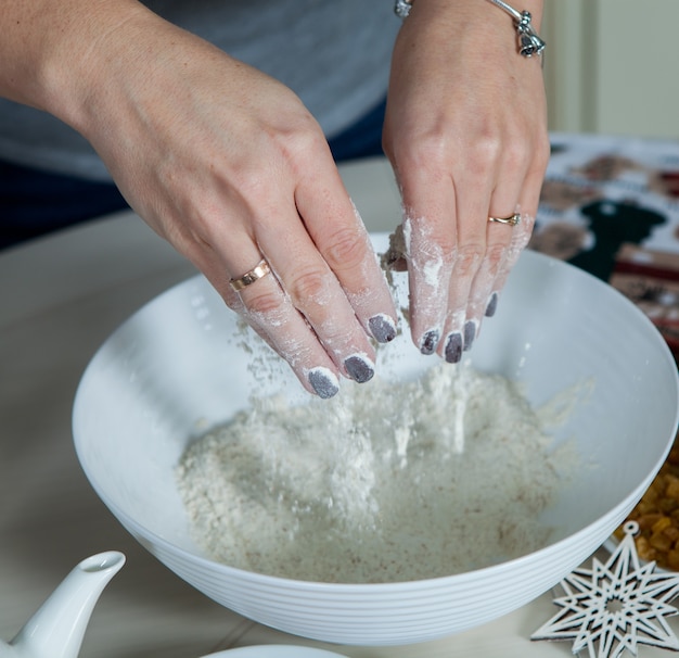 Frau, die Torte mit Zutaten zum Backen von Kuchen zubereitet