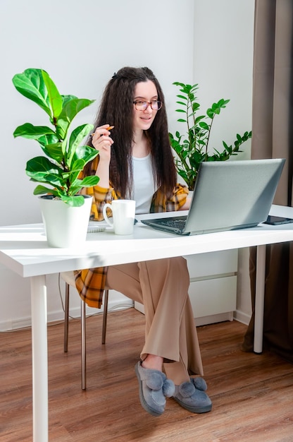 Frau, die über einen Videoanruf am Arbeitsplatz spricht, führt Konferenzen durch und trainiert die Arbeit zu Hause