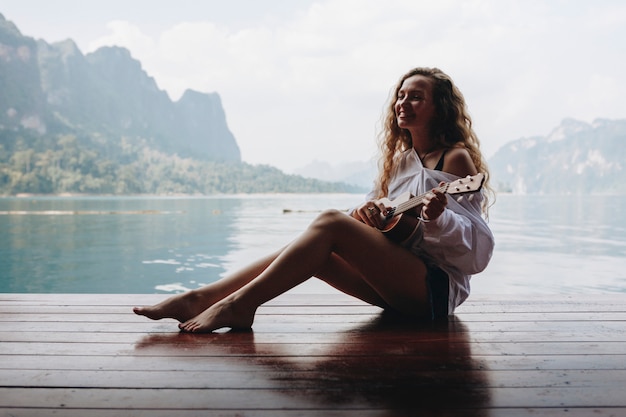 Frau, die Ukulele durch das Wasser spielt