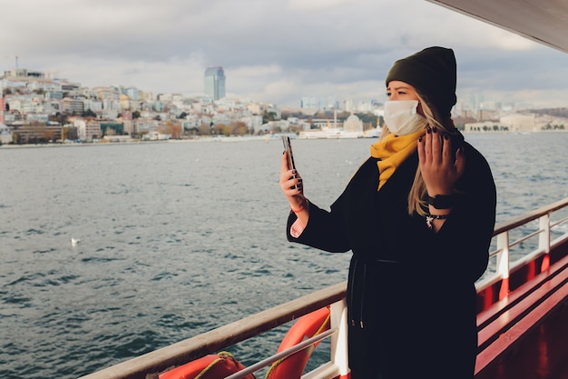 Frau, die Videoanruf auf Handy in der Seelandschaft nimmt.