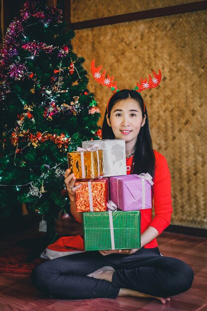 Frau, die viele Geschenkbox auf dem Weihnachtsfest trägt.