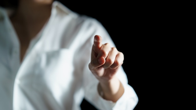 Frau, die visuellen Bildschirm mit ihrem Finger berührt.