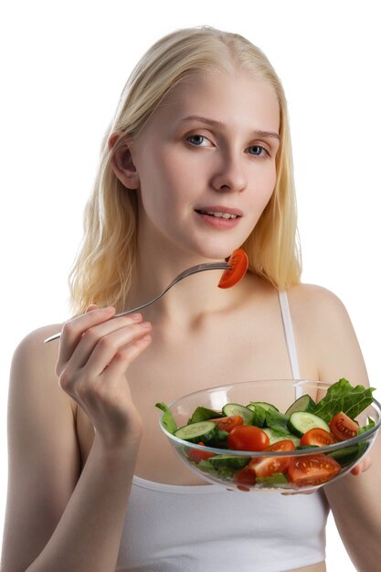 Frau, die vom frischen Salat in der Glasschüssel für Diät isst.