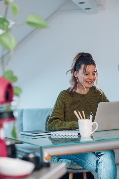 Frau, die von zu Hause aus an einem Laptop arbeitet