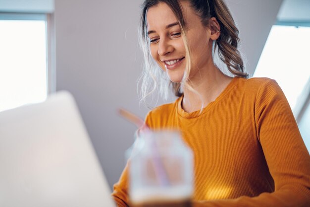 Frau, die von zu Hause aus an einem Laptop arbeitet