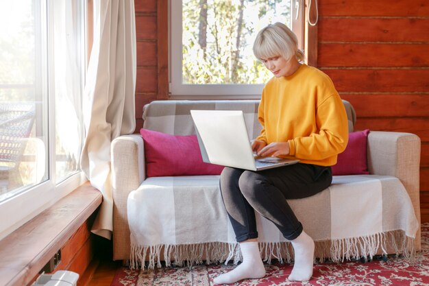 Frau, die von zu Hause mit Laptop arbeitet