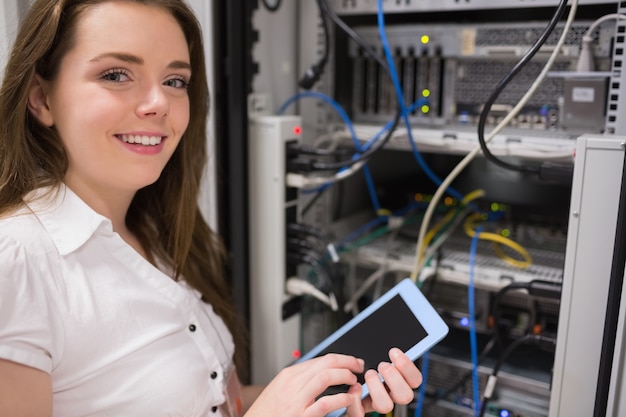 Frau, die vor dem Datenspeicher beim Halten eines Tabletten-PC steht