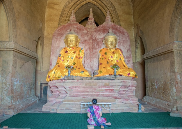 Frau, die vor der Buddha-Statue betet