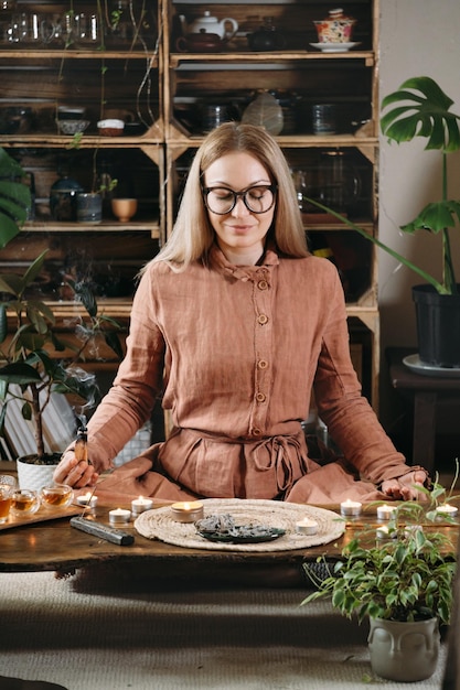 Frau, die während der Meditation Palo Santo hält