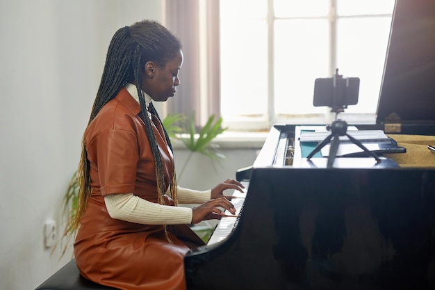Frau, die während der Online-Sendung Klavier spielt