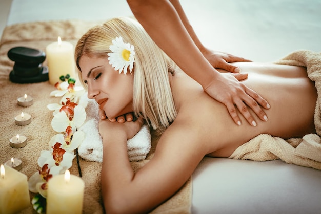 Frau, die während einer Rückenmassage an einem Spa genießt.