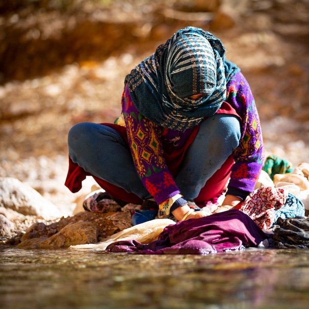 Frau, die Wäsche im Fluss der malerischen Dades-Schlucht im Atlasgebirge wäscht?