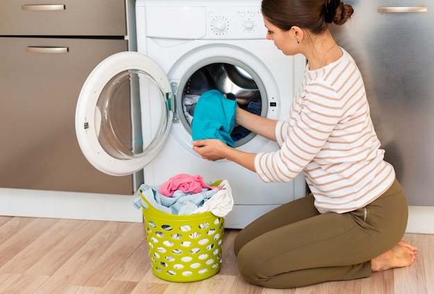 Foto frau, die waschmaschine der kleidung herausnimmt