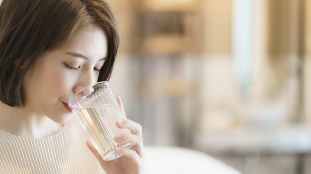 Frau, die Wasser aus einem Glas trinkt