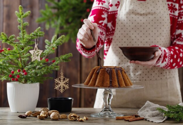 Frau, die Weihnachtskuchen auf Holzküche kocht