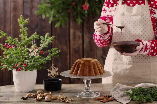 Frau, die Weihnachtskuchen auf Holzküche kocht