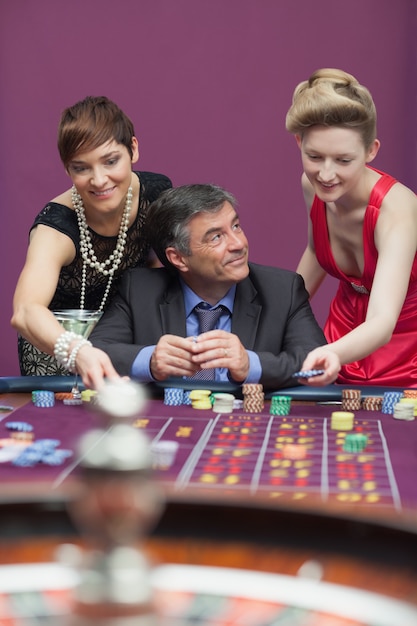 Frau, die Wette für Mann am Roulette setzt