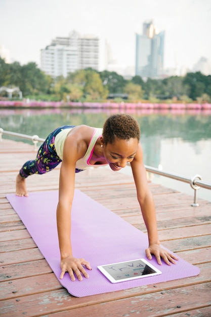 Foto frau, die yoga am park tut