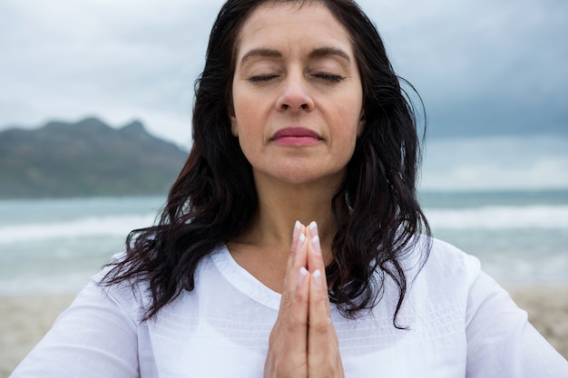 Frau, die Yoga am Strand durchführt