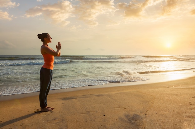 Frau, die Yoga am Strand tut