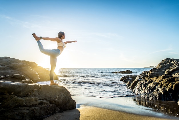 Frau, die Yoga am Strand tut