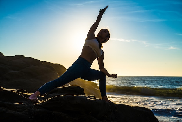 Frau, die Yoga am Strand tut