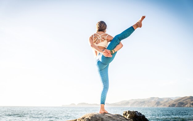 Frau, die Yoga am Strand tut