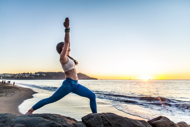 Frau, die Yoga am Strand tut