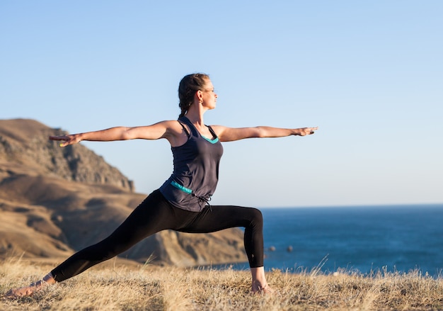 Frau, die Yoga auf der Natur im Freien tut