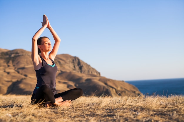 Frau, die Yoga auf der Natur im Freien tut