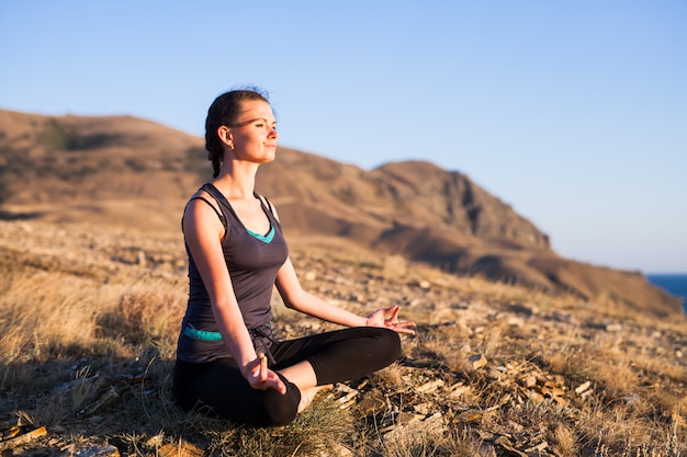 Frau, die Yoga auf der Natur im Freien tut