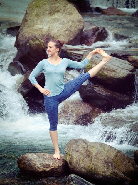 Frau, die Yoga-Balance-Asana Utthita Hasta Padangushthasana ausstreckt HandT o Big Toe Pose im Freien macht