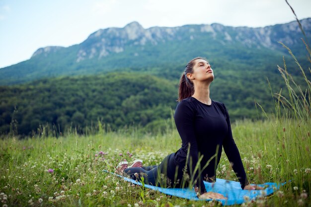 Frau, die Yoga-Übung im Berg praktiziert