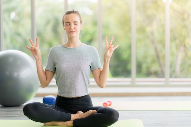 Frau, die Yoga im Fitnessstudio praktiziert