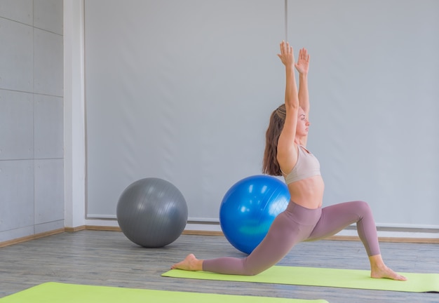 Foto frau, die yoga im fitnessstudio praktiziert