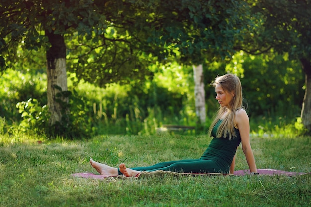 Frau, die Yoga im Sommerpark tut