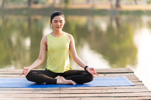 Frau, die Yoga praktiziert, das Yoga im Morgenpark tut