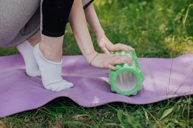 Frau, die Yoga praktiziert und im Freien meditiert Mädchen bereitet Material für den Übungsunterricht im Garten vor Weibliches Glück und Yoga-Konzept Während der Quarantäne aufgrund der Ausbreitung des Coronavirus