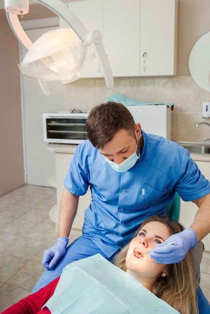Frau, die Zähne beim Zahnarzt untersucht