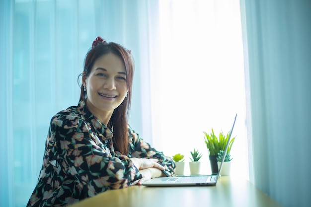 Frau, die zu Hause an Laptop arbeitet