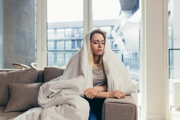 Frau, die zu Hause auf dem Sofa sitzt, depressives Mädchen hat eine harte Zeit mit Stress