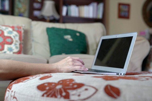 Frau, die zu Hause auf ihrem Laptop tippt