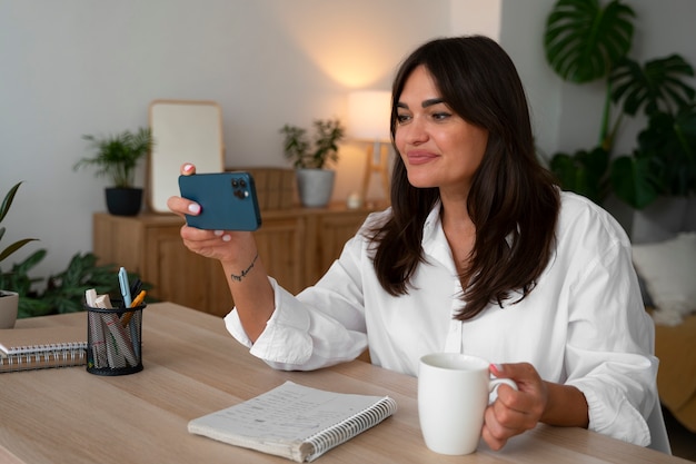 Foto frau, die zu hause mit einem smartphone einen videoanruf macht