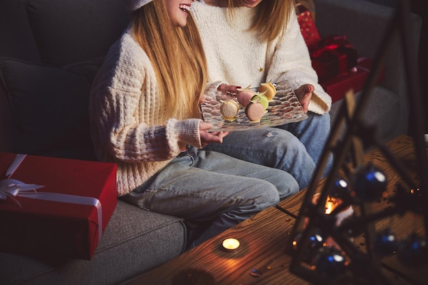 Frau, die zu Weihnachten glückliche Tochter mit Makronen behandelt